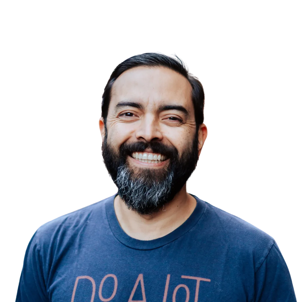 Pat Flynn, known as Deep Pocket Monster, smiling in a 'Do A Lot' t-shirt