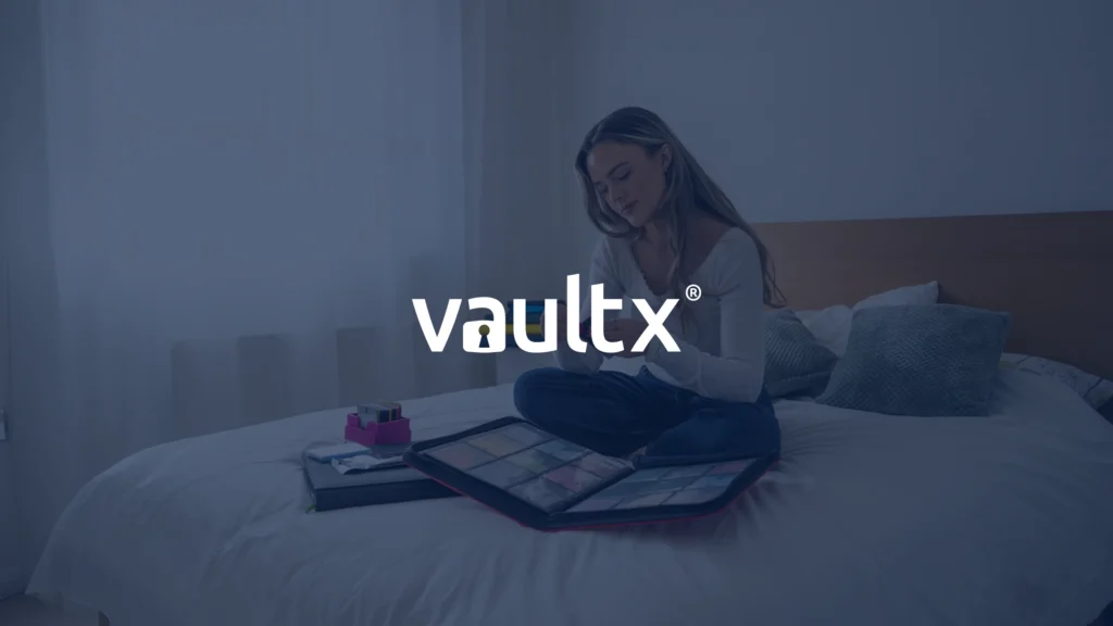 VaultX logo over a photo of a collector sitting on a bed sorting trading cards into a binder and storage case